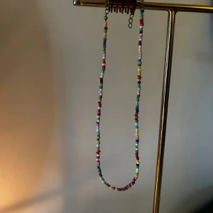 Färgglatt pärlhalsband - Ett långt halsband med små pärlor i olika färger som rosa, blå, grön, gul, vit och röd. 💕