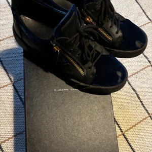 Giuseppe Zanotti svarta sneakers - Snygga svarta sneakers från Giuseppe Zanotti med blå sammet. Skorna har lite slitning där fram men annars i bra skicka. Bara å höra av sig vid frågor priset kan diskuteras tar även byten