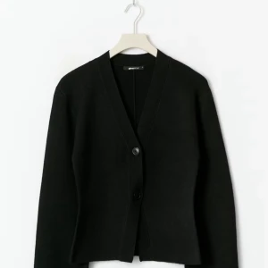 Svart kofta från Gina Tricot - Svart, stilren kofta från Gina Tricot med v-ringad hals och två knappar framtill. Koftan är knappast använd💕