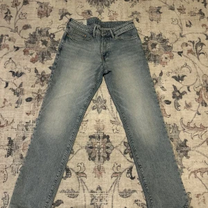 Ljusblå straight jeans från H&M - Säljer ett par ljusblå jeans från H&M med straight regular fit. Klassisk femficksmodell med normal passform och raka ben. Jeansen är i denim med snyggt tvättad look och passar perfekt till en avslappnad stil.