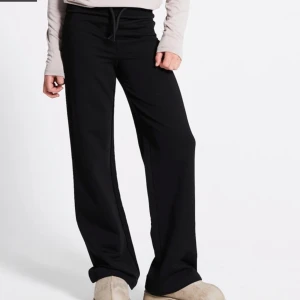 Svarta mjukisbyxor  - Svarta mjukisbyxor från lager 157 i storlek XS. Byxorna har en bekväm midja med snörning och är tillverkade i mjukt material som passar chill dagar. Klassisk rak passform och stilren look, perfekta för att hänga med kompisar eller bara ta det lugnt.