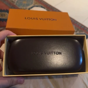 Louis Vuitton monogram solglasögon - Säljer ett par svarta Louis Vuitton solglasögon med ikoniskt monogrammönster på glasen. Modellen har en bred, futuristisk sköldform och kommer med originalfodral, putsduk och box. Tillverkade i Italien, riktigt lyxig vibe och snygg detalj till din look.priset kan diskuteras 