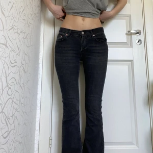 Svarta bootcut jeans från Gina Tricot - Snygga svarta jeans från Gina Tricot i storlek 36. Modellen har bootcut-ben och låg midja, med klassisk femficksdesign och knappstängning. Jeansen är gjorda i stretchigt denim som sitter riktigt bra och framhäver figuren.