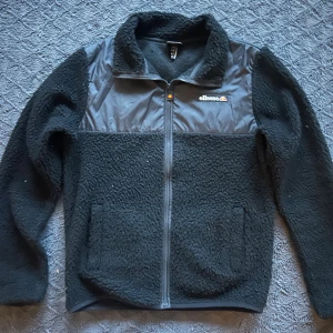 Fleecejacka från ellesse - Svart teddyjacka från Ellesse. Tillverkad i 100% polyester. Den är i storlek S och modellen på bilden är 182 cm lång och väger 70 kg. Den är i topp skick inga defekter 8/10✅. Hör av dig om du har några frågor 