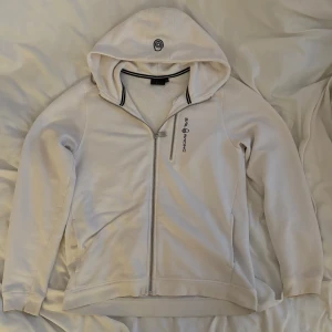 Vit sail racing hoodie - Vit zip-up sail racing hoodie i storlek 170, köpt på kids brandstore, knappt använd med nån minimal fläck, skriv om du har frågor 