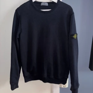 Svart Stone Island sweatshirt - Svart sweatshirt från Stone Island. Tröjan har Stone Island patchen på vänster ärm och är tillverkad i mjuk bomull.