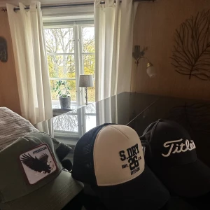 Tre kepsar: Freedom, S.DRY, Titleist - Säljer tre snygga kepsar! En olivgrön Freedom-keps med örnpatch, en svartvit S.DRY 26 Division truckerkeps med mesh och brodyr, samt en svart Titleist Pro V1 keps med vit broderad logga. 100kr styck