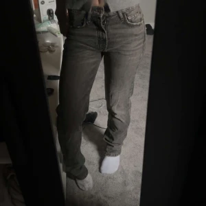 Zara Mid Jeans - Säljer ett par klassiska grå Levis 501 jeans med rak passform och normal midja. Jeansen har fem fickor, knappgylf och är tillverkade i slitstarkt bomullsjeans. Perfekta för dig som gillar en tidlös och avslappnad stil.