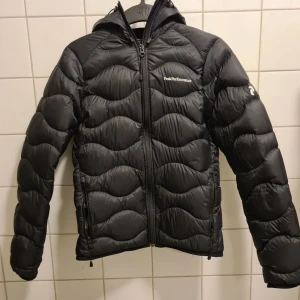 Peak Performance JR Jacka - Nypris 2000 SEK  Peak Performance Helium Down Jacka  Använd några månader.  Bra skick förutom höger ficka som är något sliten (bild 6). Kedjan fungerar dock fortfarande.  O.B.S - Juniorstorlek (S). Vuxen XXS-XS  Bröstvidd: 48cm Rygglängd: 60cm.