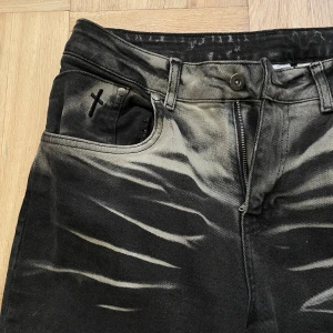 The Ragged Priest Jeans bootcut med zebra-mönster - Svarta bootcut jeans från The Ragged Priest med grått zebra-inspirerat mönster och råa kanter nedtill. Jeansen har klassisk femficksdesign, dragkedja och knapp framtill samt en cool detalj med kors-stitching vid fickan. Perfekt för dig som vill sticka ut. Mina favvo jeans som tyvärr ej kommer till användning, orginalpris ca 1200kr 