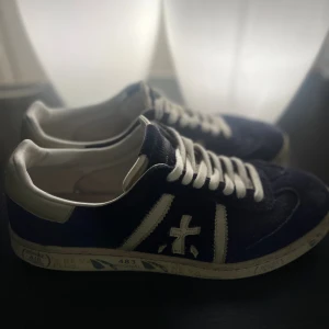 Premiata 483 original - Snygga sneakers från Premiata i mörkblå mocka med vita detaljer och snörning. Perfekt för dig som gillar stilrena skor