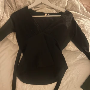 V-ringad blus med knytning  - Svart blus från Nelly som man kan välja att knyta fram eller bak 