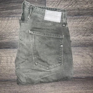 Replay Anbass jeans  - Snygga Replay Anbass jeans i mörkgrå färg med klassisk femficksdesign och raka ben. Jeansen har detaljerad söm på bakfickorna.  OBS jag är osäker på om färgen är khaki alltså mörkgrön heller mörkgrå då de ser lite olika ut i olika ljus, jag tar ej emot retur om man blir missnöjd :) midja 43cm, längd 103cm. JAG SKICKAR INGA FLER BILDER PÅ NÄR JAG BÄR JEANSEN :) 17 