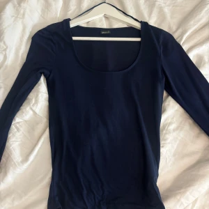 Mörkblå långärmad topp Gina Tricot - Säljer en mörkblå långärmad topp från Gina Tricot i storlek XS. Toppen har en rundad, djup halsringning. Materialet är mjukt och stretchigt. Även slittar i båda ärmarna 