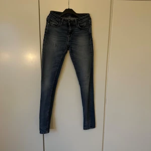 Tiger of Sweden jeans  - Snygga blå jeans med klassisk femficksdesign. Jeansen har lätt slitna detaljer och kontrastsömmar, vilket ger en cool och modern look. Materialet är jeans med stretch för extra komfort. Perfekt för dig som gillar en smal siluett.