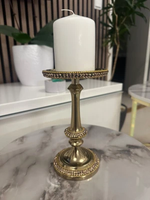 Guldig väst med paljettdetaljer - Säljer en snygg guldig väst med glittriga paljettdetaljer. Västen har en klassisk form och är tillverkad i ett syntetmaterial som ger en lyxig känsla. Perfekt för dig som vill sticka ut och addera lite extra bling till din outfit.