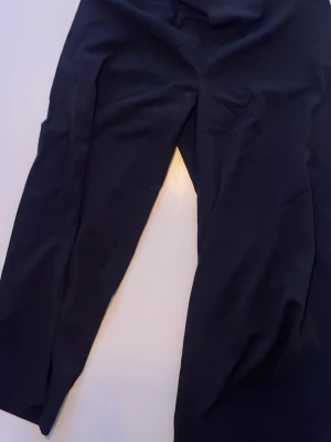 Svarta kostymbyxor med rak passform - Snygga tunna svarta kostymbyxor med rak passform och klassisk design. Perfekta för dig som gillar stilrena och enkla plagg. Materialet känns mjukt och har en lätt stretch för extra komfort. Passar till skjorta eller t-shirt beroende på humör.