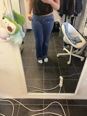 Blå velourbyxor Juicy Couture S - Säljer ett par blå velourbyxor från Juicy Couture i storlek S. Byxorna har snörning i midjan, raka ben och fickor både fram och bak med snygga detaljer. Supermjuka och perfekta för en chill look.Jättefint skick förutom att en metall del saknas.