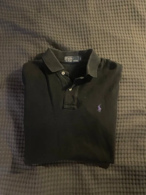 Ralph Lauren piké - En mycket fin piké tröja från Ralph Lauren i svart. Tröjan är i fint skick och är storlek S. Vid minsta fråga tveka inte att skicka ett meddelande!