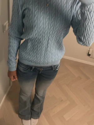 Ljusblå stickad tröja med kabelmönster - Säljer en ljusblå stickad tröja med klassiskt kabelmönster. Tröjan har rund hals, ribbade muddar och lång ärm. Perfekt för dig som gillar en chill och stilren look. Passar till jeans eller kjol och är supermysig under kyliga dagar. Aldrig använt köpt för något år sedan skulle säga att det passar xs-s passar säkert m med.