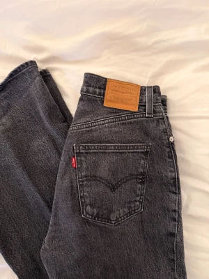 Levi's 70s High Flare gråa jeans - Säljer ett par Levi's Premium 70s High Flare jeans i svart tvättad denim. Modellen har hög midja och utsvängda ben. Storlek W26 