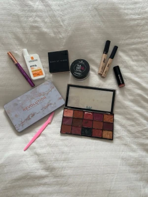 Smink paket  - Säljer en ögonskuggspalett från Revolution med 15 olika nyanser i varma och neutrala toner, allt från nude till rödbrun och guld. Paletten har en snygg marmorerad design och inbyggd spegel, perfekt för att skapa olika looks.