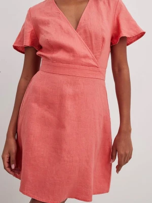 Korallrosa klänning från NA-KD - Kortare klänning i 100% linne från Na-kd. Har öppen rygg med knytband. Storlek 32 men passat även mig som är en XS. Använd max 2 gånger så i jättefint skick inga defekter. 