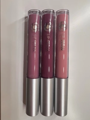 3 st HELT OANVÄNDA LÄPPGLANS 💄 💗 - Säljer ett set med tre läppglans från Depend i snygga nyanser: en dammigt rosa, en mörkare plommonlila och en mjuk nude-rosa. Dom är såklart aldrig använda eller öppnade! Fick dom i en julkalender men inte riktigt min stil.