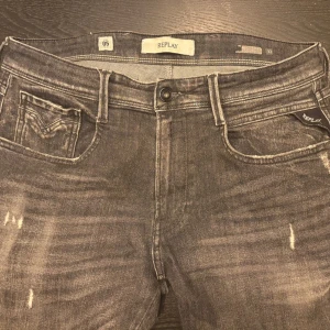 Replay svarta jeans med slitningar - Säljer ett par svarta Replay jeans med snygga slitningar och tvättade detaljer. Jeansen är uppsydda cirka 1 cm men påverkar inte jätte mycket på storleken. Dessa byxor går ej att få tag på längre i butik, därför är priset högre än vanligt, men priset kan såklart diskuteras!!