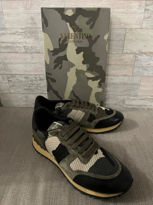 Valentino Garavani Rockrunner sneakers - Snygga Valentino Garavani sneakers med ett coolt camouflage-mönster. Skorna har snörning och en kombination av gröna och svarta detaljer. Perfekta för en trendig look. Passar även bra på storlek 44