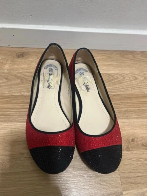 Red & Black Ballet Flats with Rhinestones – Size EU 38 - Stylish ballet flats in red and black with small rhinestone details. Comfortable slip-on design, perfect for everyday wear or special occasions. Brand: Malafolie Size: EU 38 Color: Red & black Style: Ballet flats / flat shoes Condition: Used, in good condition. Some visible wear on the inner sole (see photos), but the outside looks nice and the shoes are fully wearable. Great for parties, casual outfits, or as a pop of color 💃 Feel free to message me if you have any questions! 
