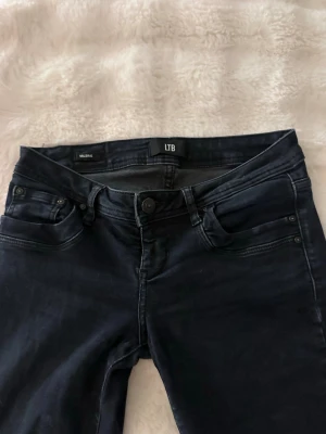 Nattblå bootcut jeans från LTB - Snygga nattblå jeans från LTB med klassisk femficksdesign och bootcut-ben. Jeansen har en mörk tvätt och är tillverkade i stretchigt denim för skön passform. Perfekta för dig som gillar en tidlös look med lite extra edge.