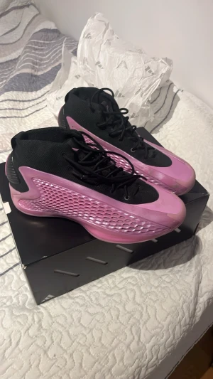 Adidas A1 i svart och rosa KAN DUSKTERA PRIS - Säljer ett par Adidas sneakers med svart ovandel i stickad syntet och rosa detaljer på sidorna och sulan. Skorna har snörning, rund tå och en cool texturerad sula i rosa. Perfekt för dig som gillar sportig stil och vill sticka ut med färg.