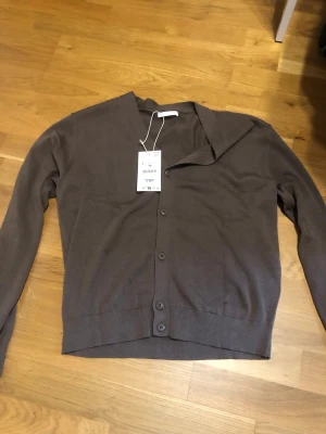 Kofta - Zara - Säljer en brun/beige kofta från Zara i storlek L. Helt ny aldrig använd med prislapp. Köpt för någon månad sedan för nypris ca 430kr.  Storleken är bra, men skulle definitivt passa en med storlek M också. Säljer då den ej används.  Skriv till mig vid minsta fundering