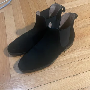 Ett par feta Chelsea boots i mocka, inga defekter. - Svarta mocka Chelsea boots, i storlek 42. Passar till en stilren outfit. Pris kan diskuteras. Skickat så snabbt jag kan.