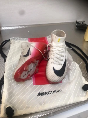 Nike Superfly 10 Elite Airzoom - Storlek Eu 38. Har använt dem endast 2 träningar så dem är i princip helt nya. Det är Elite modellen så högsta modellen. Dem har en hög skaft som sitter skönt runt vristen. Väldigt hållbara fotbollskor.  Perfekta Fotbollskor för att använda för både matcher och träningar. (Elite bag ingår.)   Ny pris 3199kr säljer för endast 1200kr. 