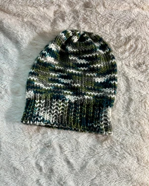 Mönstrad stickad mössa i grönt och blått - Säljer mössa med coolt mönster i grönt, blått, vitt och grått. Mössan är gjord i mjukt garn och har en ribbad kant för extra komfort. Perfekt för dig som gillar unika accessoarer med lite street-vibe.