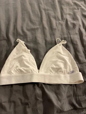 Vit triangelformad linnetopp Frank Dandy - Säljer en vit triangelformad linnetopp från Frank Dandy. Toppen har smala justerbara axelband, mjuk resår under bysten och hakknäppning bak. Tillverkad i bomull för en skön känsla. Perfekt för en chill och enkel stil.