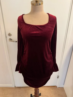 Vinröd sammetsblus från SHEIN XL - Säljer en vinröd blus från SHEIN i storlek XL. Blusen har en mjuk, sammetsliknande yta, långärmade ärmar med lätt volang vid mudden och en fyrkantig ringning framtill. Perfekt för dig som gillar djupa färger och skön passform.