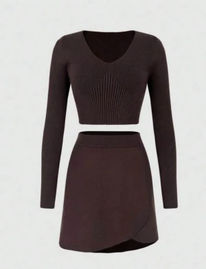 Brun omlottkjol i stickat material - Mörkbrun kort omlottkjol i stickat material med bred midjeresår. Kjolen har en enkel och stilren design som ger en snygg siluett. Perfekt att matcha med en croppad topp för en trendig look.helt ny 