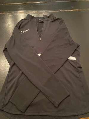 Svart Nike tröja - Svart Nike tränings tröja med kort dragkedja. Inga skador.