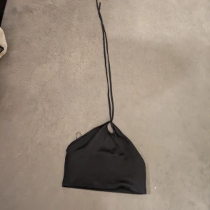 Svart halterneck linnetopp - Säljer en svart halterneck linnetopp med smala knytband i nacken. 