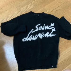 Svart stickad Saint Laurent tröja - Snygg tjocktröja från saint Laurent som är bra till vintern. Den är använd 1-3 gånger max och i väldigt bra skick, inga defekter! Vid snabb affär kan ett bra pris tillkomma!