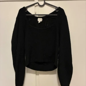 Svart croppad stickad tröja - Säljer en svart croppad stickad tröja med bred, djup urringning och långa ärmar. Tröjan har en loose passform och är perfekt för dig som gillar en enkel men snygg look. Supermjuk och skön att bära till både jeans och kjol.