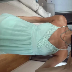 Mintgrön spetsblus med smala band - Superfin mintgrön linne med smala axelband och v-ringning dekorerad med spetsdetaljer. Linnet är lätt utställd och tyget känns luftigt och somrigt. L men passar perfekt på s