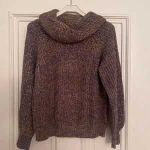 Stickad polotröja från Vila i blått och brunt - Säljer en chunky stickad polotröja från Vila i mixade blå, bruna och beige toner. Tröjan har en stor, mysig polokrage och långa ärmar. Perfekt för kyliga dagar och riktigt skön att bära. Passar dig som gillar en avslappnad och trendig stil.