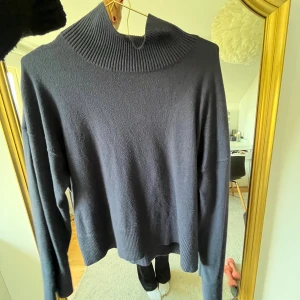 Mörkblå polotröja - Snygg mörkblå polotröja från bikbok med ribbad hög krage och breda muddar vid ärmslut och nederkant. Bra skick💕