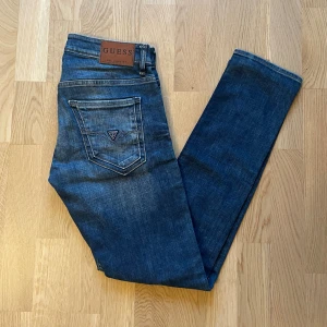 Mörkblå Guess Miami jeans W30 L32 - Jag säljer dom här riktigt snygga jeansen från Guess i storlek W30 L32. Modellen heter Miami. De är knappt använda och utan skador och defekter. Tveka inte att höra av er!                                                                  Mått: Längd=105cm. Midja=40cm
