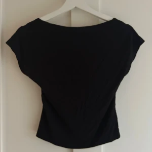 Svart topp med öppen rygg från SHEIN - Säljer en svart topp från SHEIN i storlek M. Toppen har korta ärmar och en djup, öppen rygg som ger en snygg och edgy look. Materialet är mjukt och stretchigt, perfekt för att skapa en cool outfit. Passformen är normal och toppen är enkel att matcha.