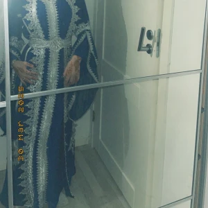 Blå långklänning med silverbroderi - Säljer en blå långklänning med vackra silvriga broderier och detaljer längs hela klänningen. Klänningen har vida ärmar och ett markerat midjebälte i samma silvriga brodyr. Perfekt för dig som vill sticka ut med en elegant och unik look.